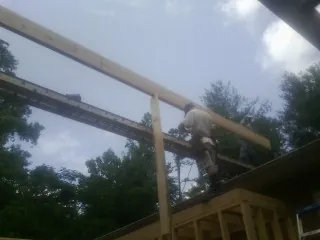 Carpenter setting a ridge beam over a new addition frame — Ice Dam Removal by Roofing Brothers in Highmount
